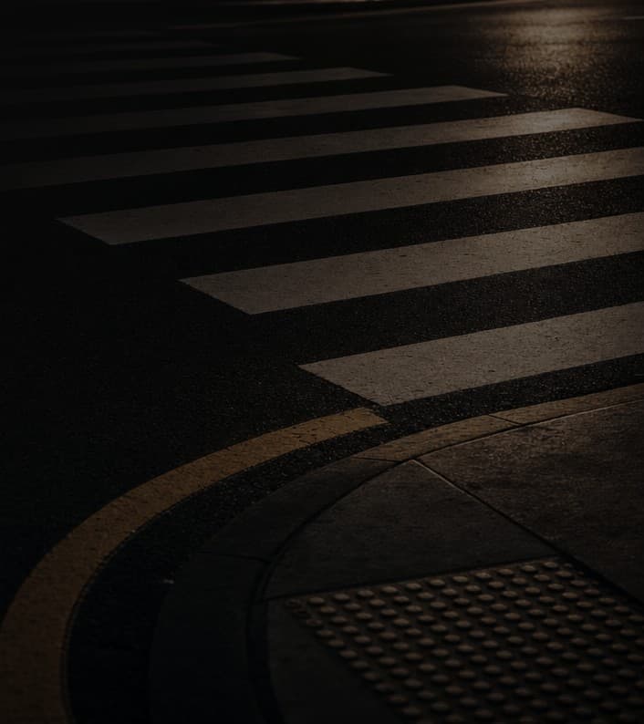 Crosswalk markings meeting the curb of a quiet roadway